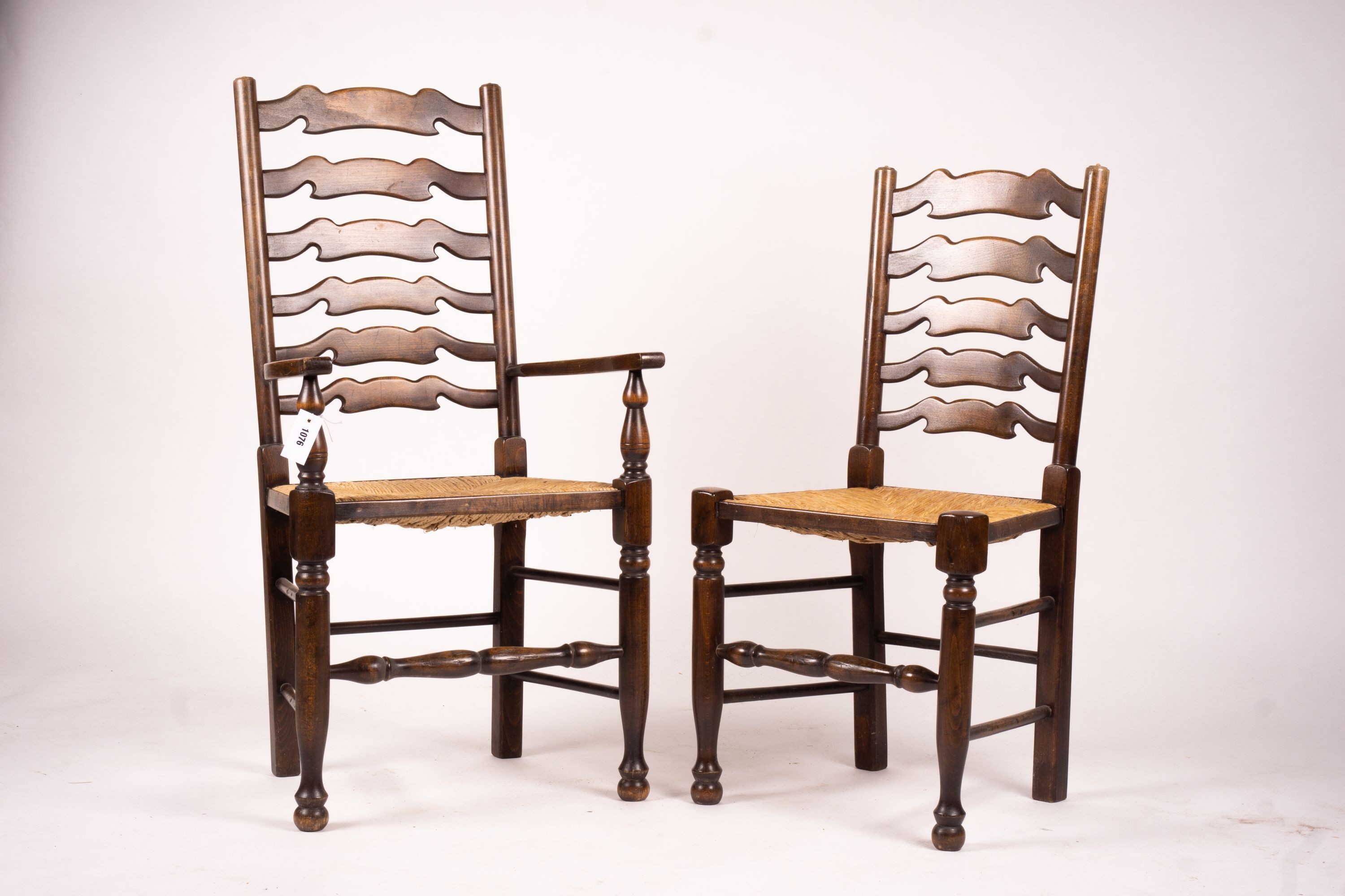 A set of ten 18th century style beech ladderback rush seat dining chairs, two with arms